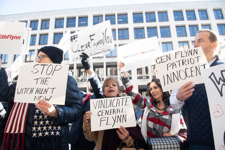 Protesters hold signs reading STOP THE WITCH HUNT NOW, VINDICATE GENERAL FLYNN and GEN. FLYNN PATRIOT INNOCENT.